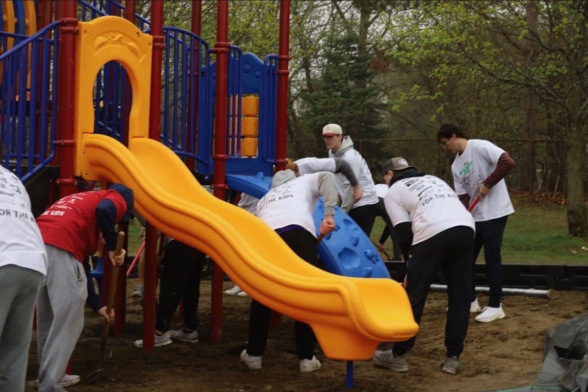 Volunteers assembling a playground slide on Build Day