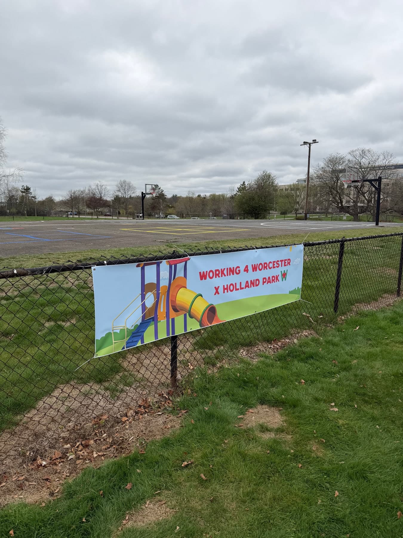 The open field beside Holland Park's basketball courts, with the Build Day banner up.
